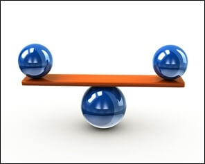 Stock photo of two blue balls balancing on a board above a centered blue ball