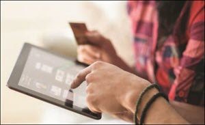 HPE stock photo of two people looking at tablet and holding credit card