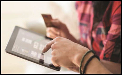 HPE stock photo of two people looking at tablet and holding credit card